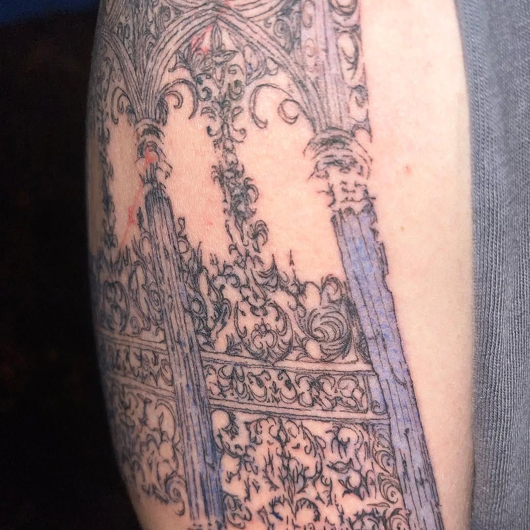 Oberarm-Tattoo: gotisches Maßwerk mit Spitzbögen, Fensterrosen und ornamentalen Säulen, feine schwarze Linien