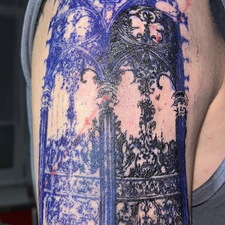 Oberarm-Tattoo: gotisches Maßwerk mit Spitzbögen, Fensterrosen und ornamentalen Säulen, feine schwarze Linien